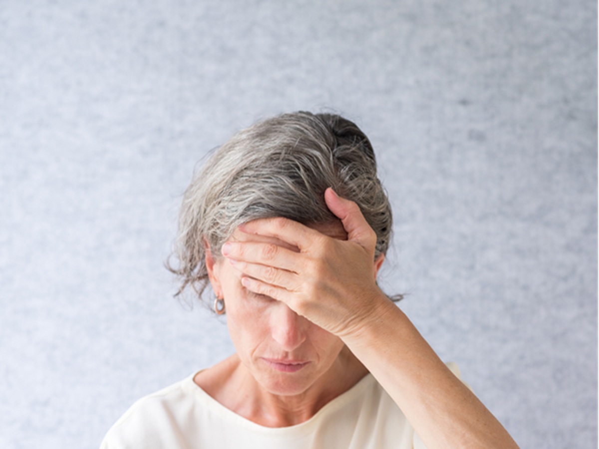 Middle-aged woman looking confused or distracted, showing signs of brain fog