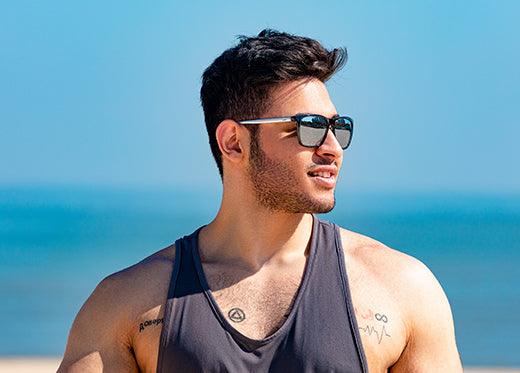 Person wearing sunglasses and a wide-brimmed hat to protect eyes from UV rays