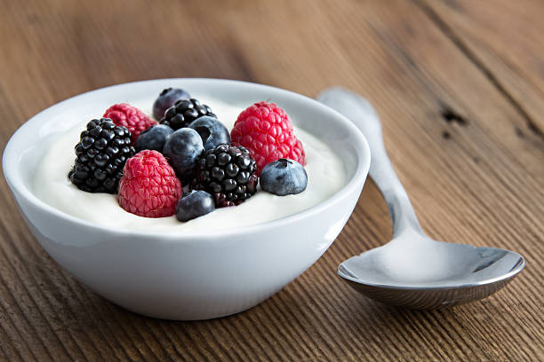 Bowl of yogurt topped with mixed fruits.