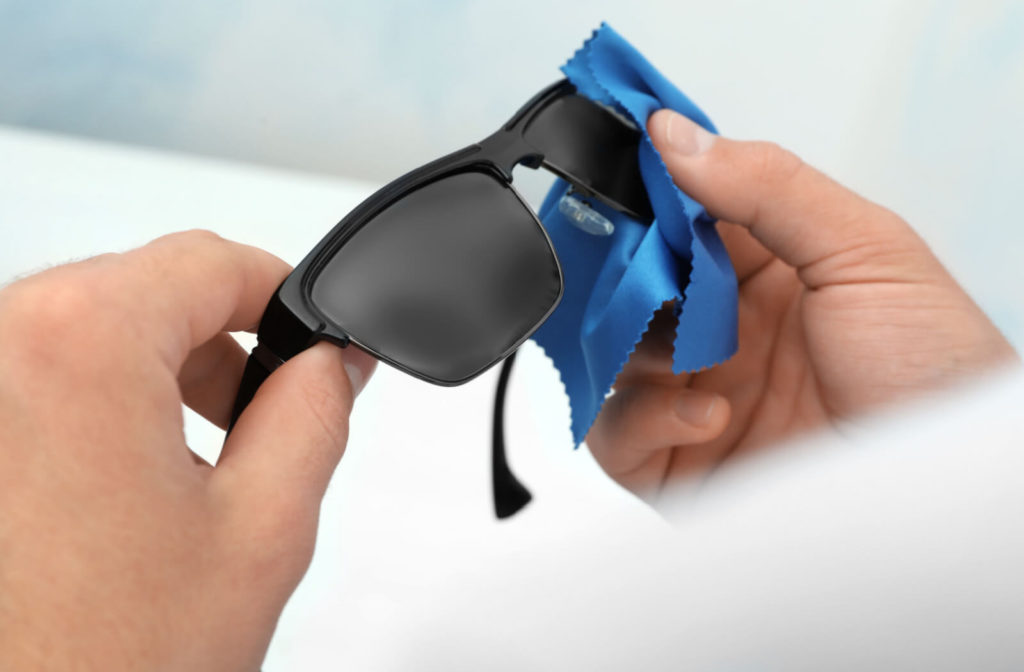 Person using microfiber cloth to clean eyeglasses and maintain eye hygiene