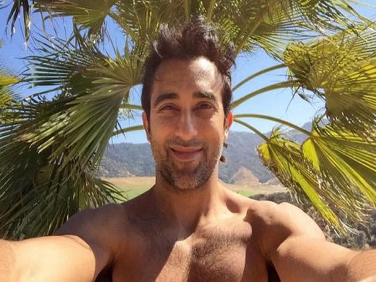 Rahul Khanna's bold Instagram photo on a turquoise sofa.