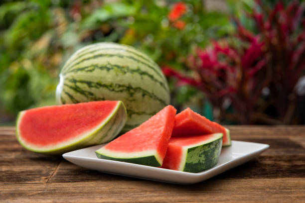 Slices of watermelon on a plate with mixed fruits around.