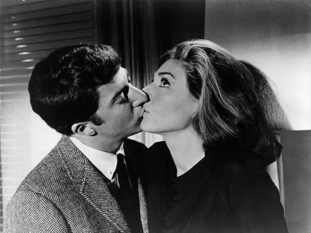 Benjamin Braddock and Mrs. Robinson sharing their first kiss in "The Graduate," showcasing the dynamic between the two characters.