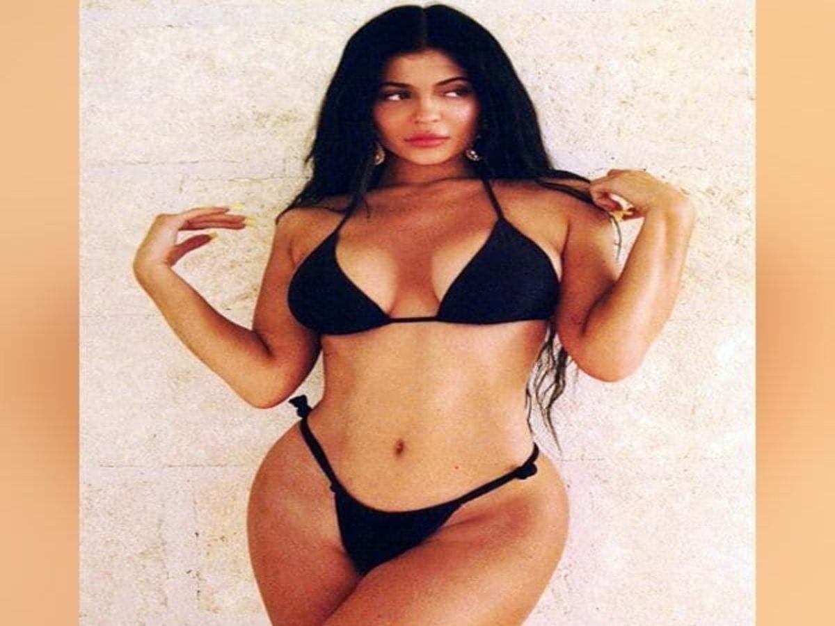 Kylie Jenner posing in a sleek black bikini, showcasing her elegant style.