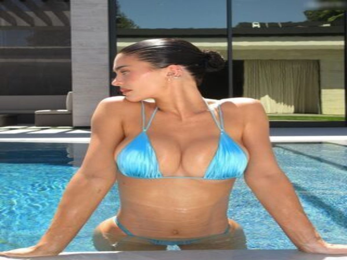 Kylie Jenner relaxing in a vibrant blue bikini by a pool, showcasing her stylish look.