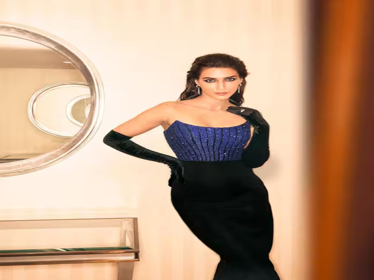 Kriti Sanon posing elegantly in a stylish blue and black gown on the red carpet.