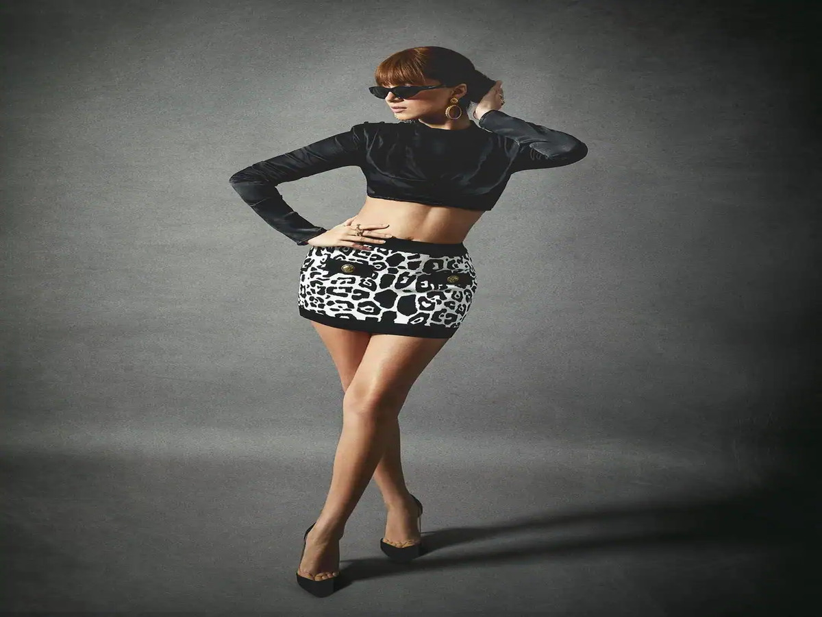 Model in a cropped black top and leopard-print skirt, showcasing a bold and fashionable silhouette.