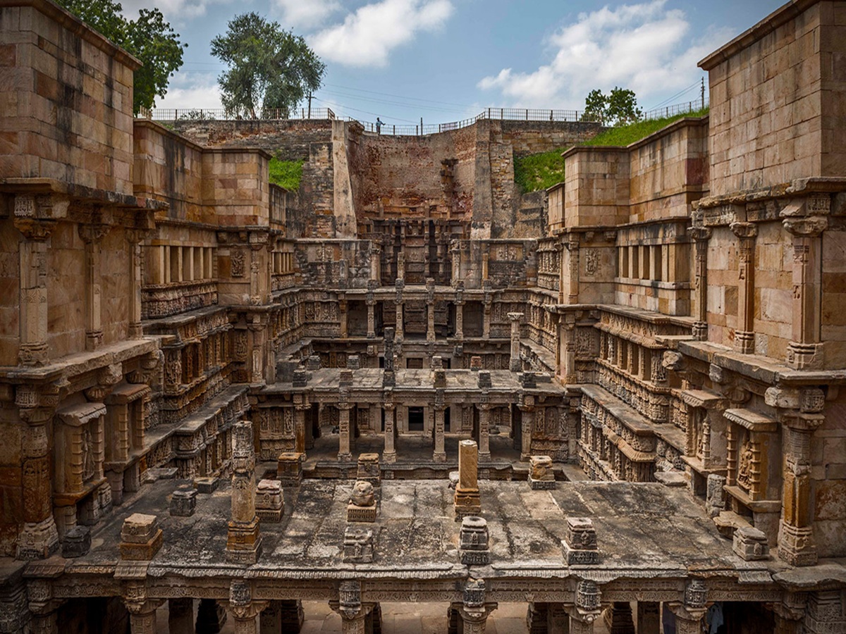 Panoramic view of Rani ki Vav stepwell in Patan, Gujarat, displaying seven tiers of ornate sandstone carvings descending to a pool of water