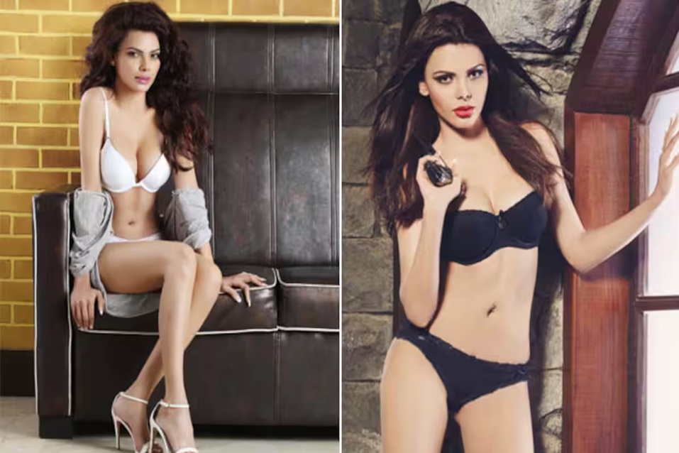 Sherlyn Chopra looking bold and confident in a black bra and red briefs, striking a powerful and sultry pose
