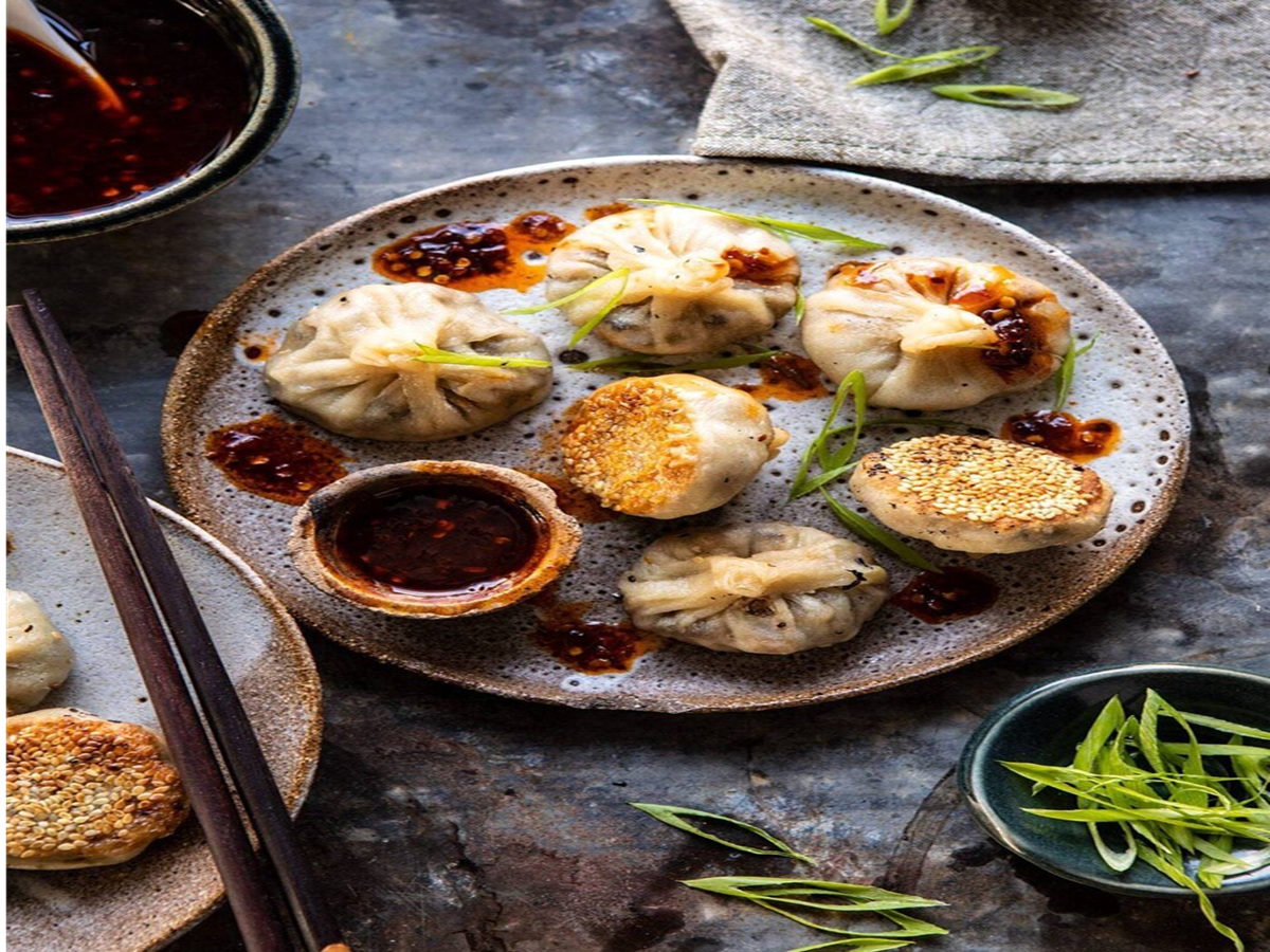 Pan-fried vegetarian mushroom dumplings with sesame crust, served with sweet chili ginger dipping sauce