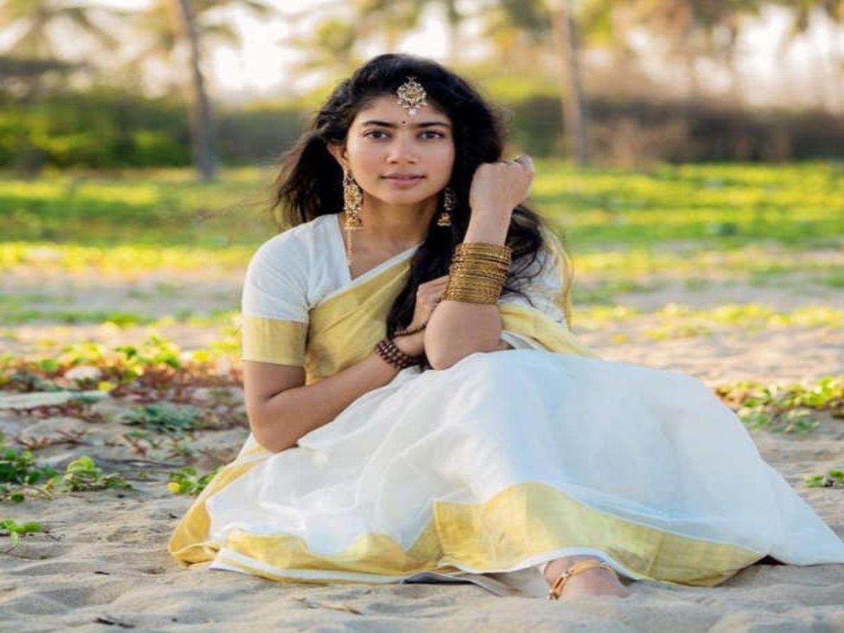 Actress in a graceful white saree with golden accents