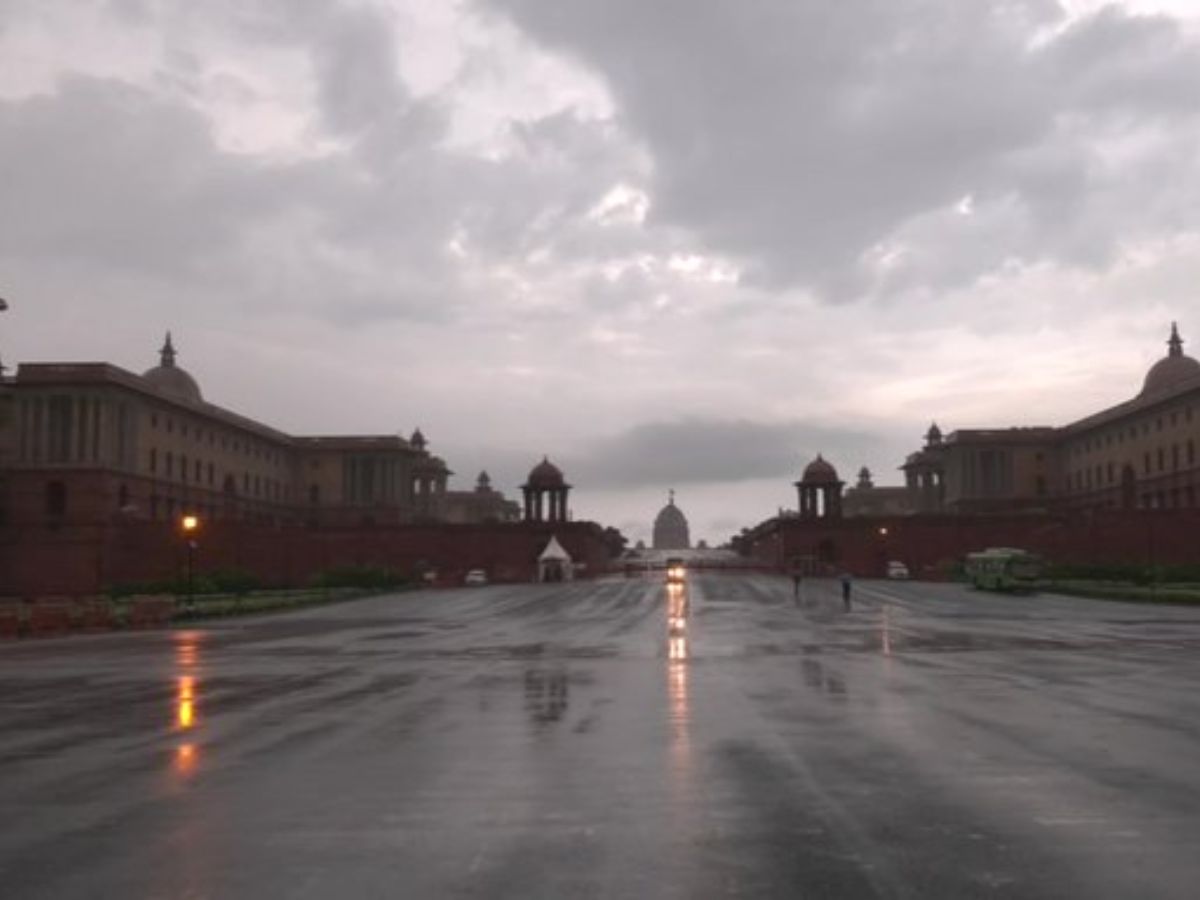 Rain-soaked Raisina Hill in New Delhi with reflective roads, cloudy skies, and distant view of Rashtrapati Bhavan.