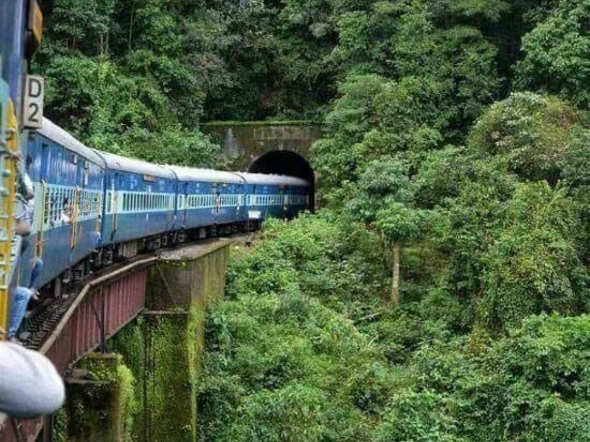 Train passing through lush green Araku Valley in monsoon