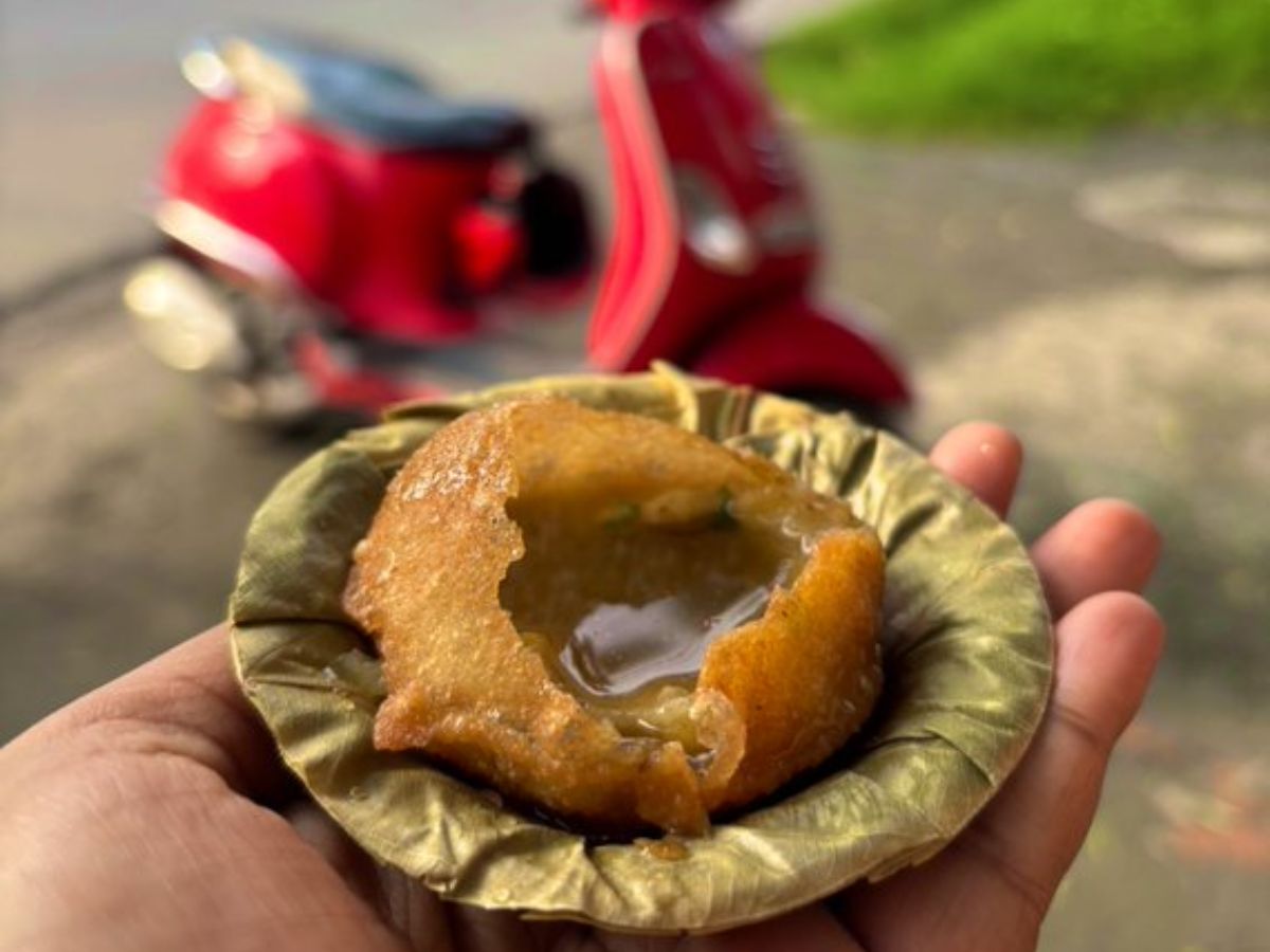 A plate of pani puri or chaat getting wet in the rain on a street food stall.