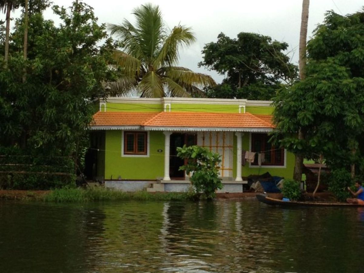 A green house surrounded by trees and dangerously rising water levels during the rainy season.