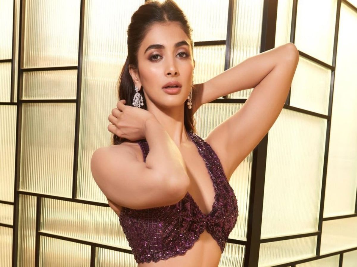 Pooja Hegde in a shimmery burgundy outfit at her brother's sangeet ceremony.