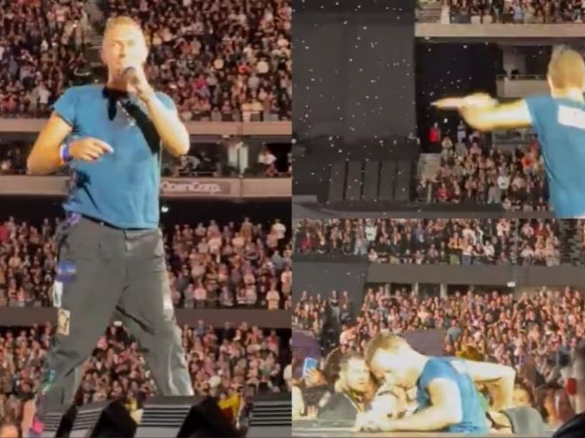 Chris Martin on stage in front of a packed arena, gesturing and interacting with fans during the viral joke.
