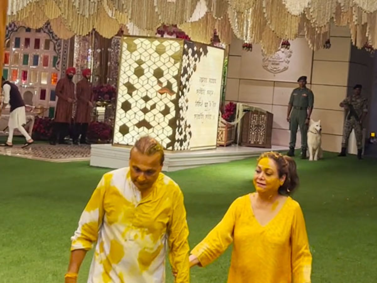 Anil and Tina walking together at an event, hand-in-hand.