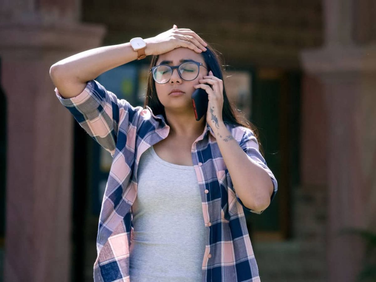 Prajakta Koli smiling as Dimple in a college setting with a laptop and casual outfit.