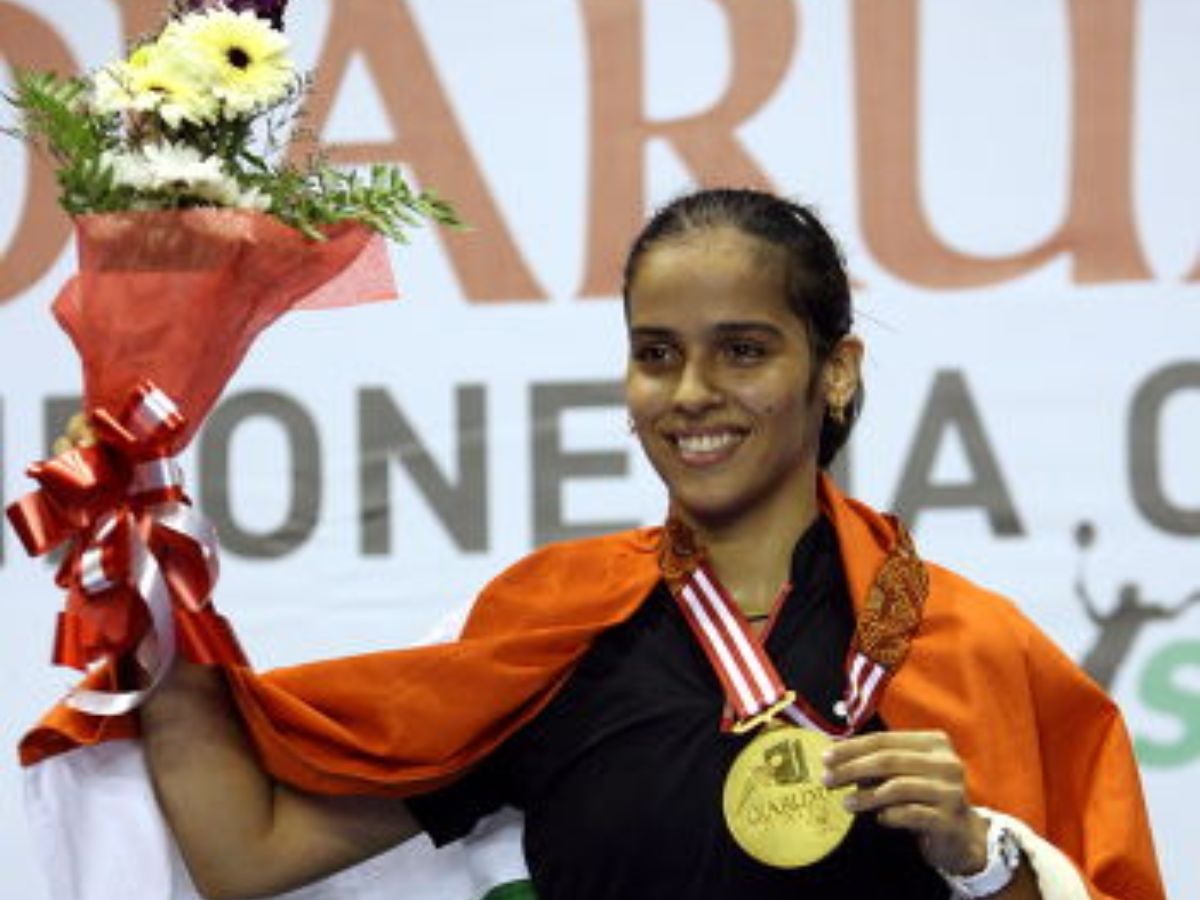 Saina Nehwal standing on the podium with the gold medal at CWG