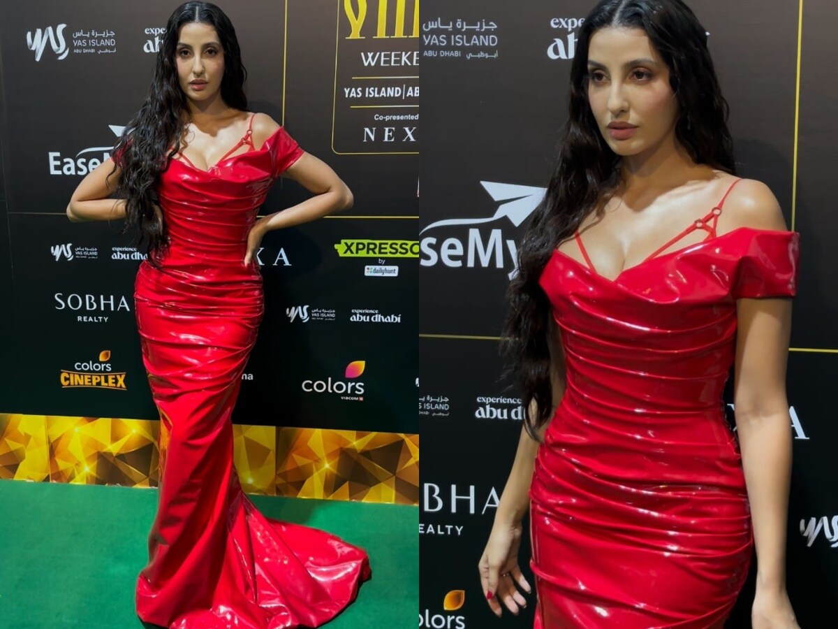 Nora in a bold red latex gown with a cutout strap.