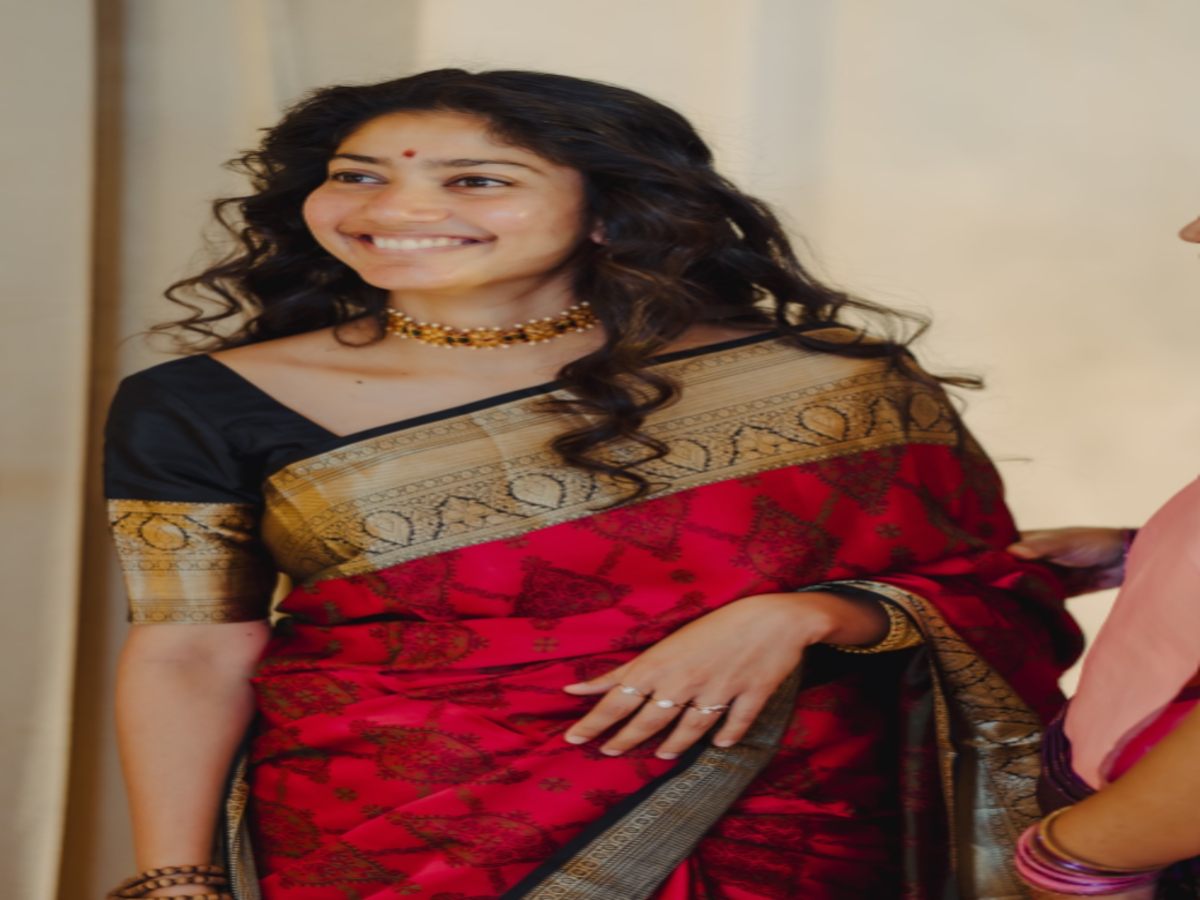 Model in an elegant red and gold saree with a black blouse